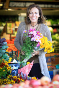 Beth Greer holding flowers at the market